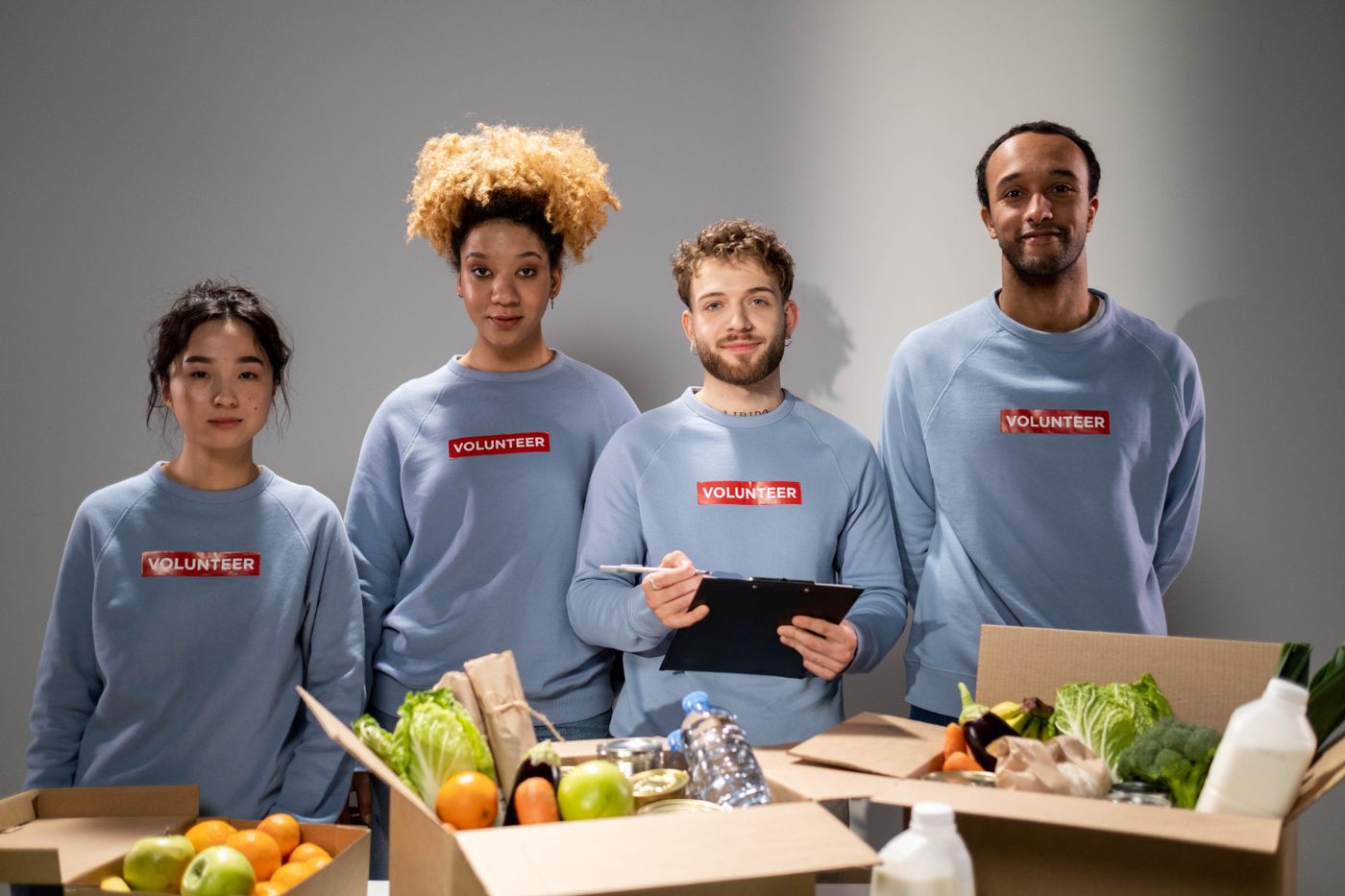 A workplace team standing behind boxes of collected food