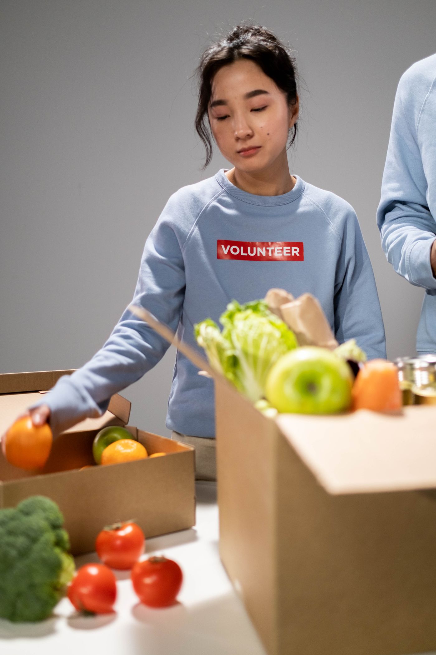 A volunteer sorting rescued fresh produce into boxes